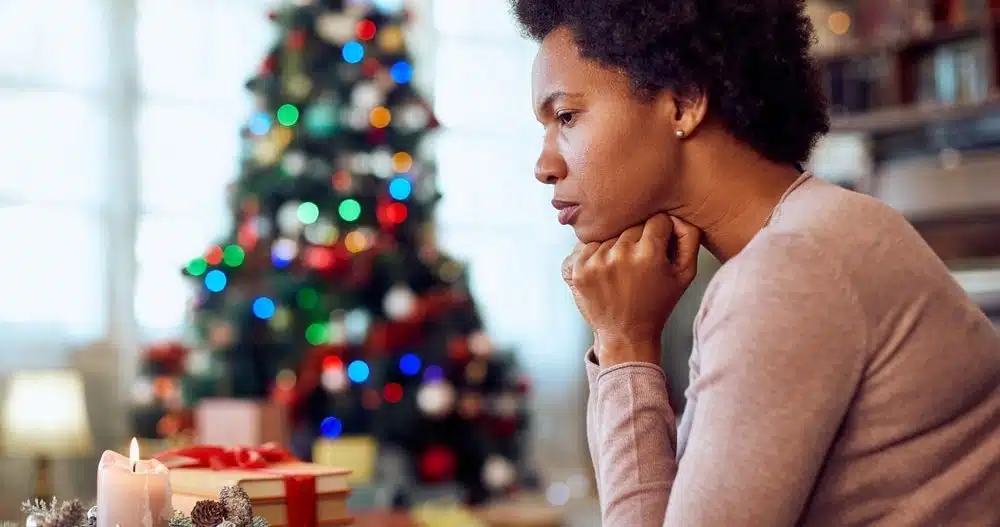 Woman sitting with head on hands experiencing grief on the holidays