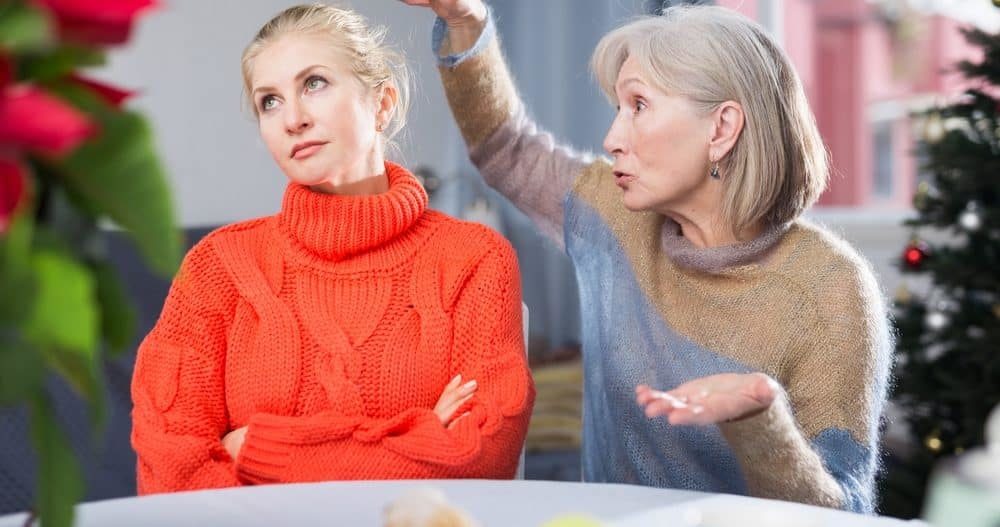 Woman creating conflict with daughter at the dinner table during the holidays