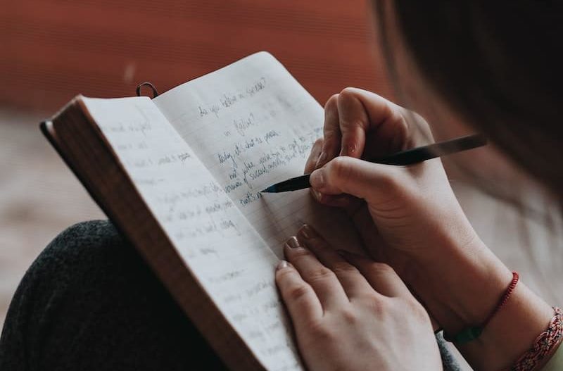 Woman writing down New Year's resolutions