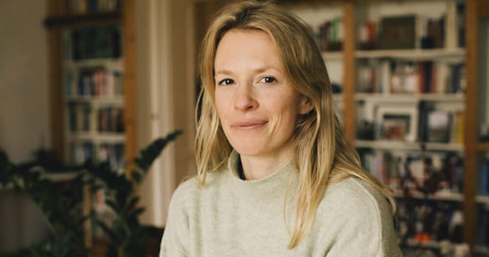 Portrait of blond woman wearing a grey sweater at home smiling