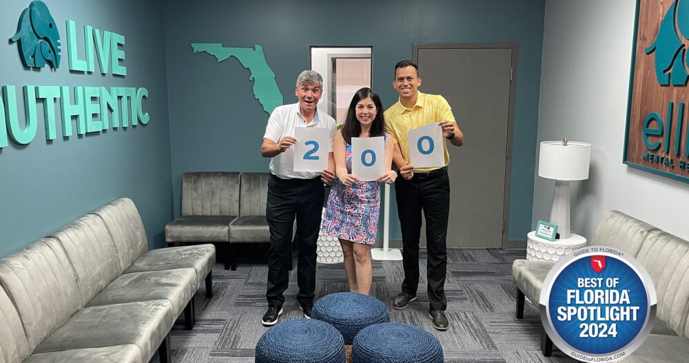 Ellie Mental Health Lake Worth, FL Franchisees receiving a Best of Florida award. The franchisees are standing with an official representative and holding signs that show the number 200