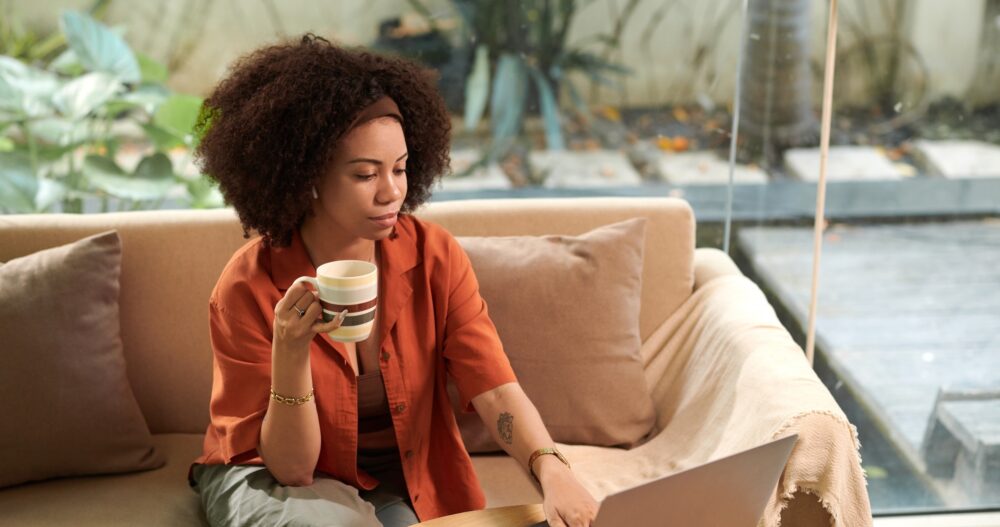 Businesswoman having morning coffee when answering emails