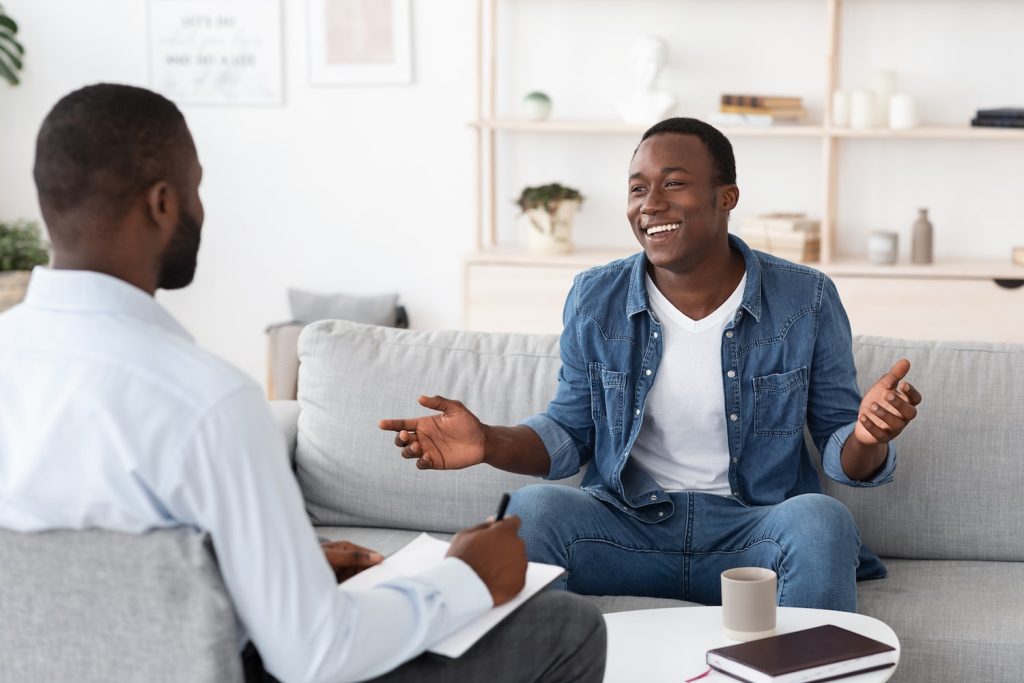 two men sitting and talking during psychedelic therapy