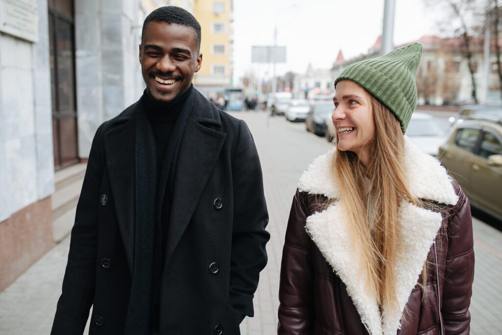 Couple walking outside in a downtown area smiling and talking with each other