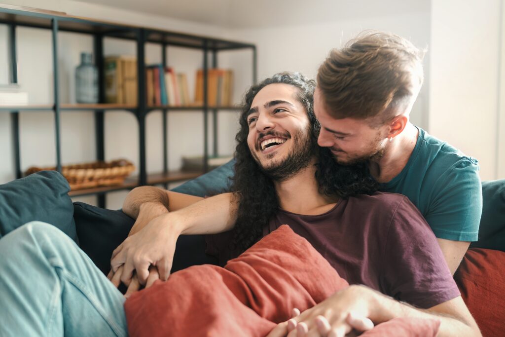 Couple cuddling on the couch smiling