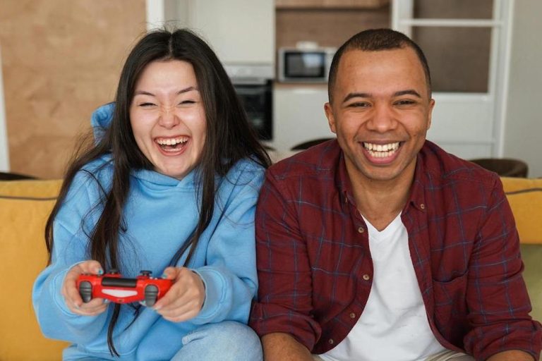 Man and woman sitting on the couch playing video games together