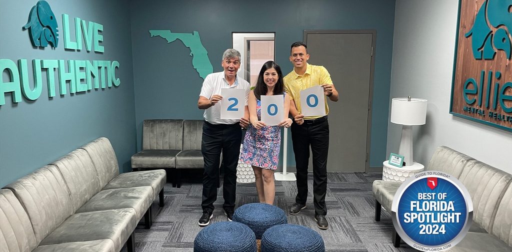 Ellie Mental Health Lake Worth, FL Franchisees receiving a Best of Florida award. The franchisees are standing with an official representative and holding signs that show the number 200
