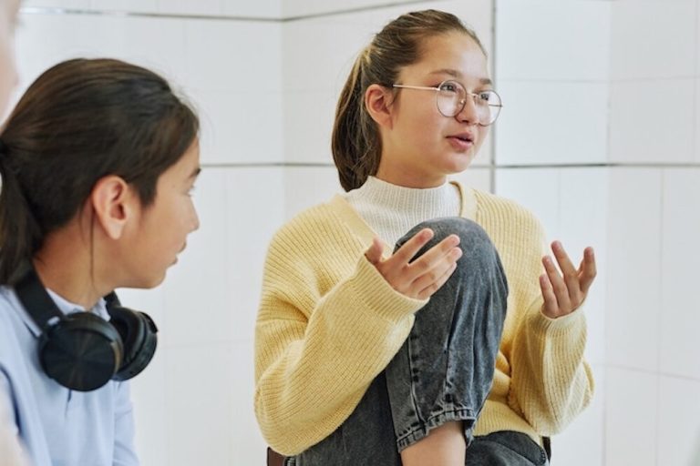 Portrait of teenage girl sharing feelings in support group circle for children