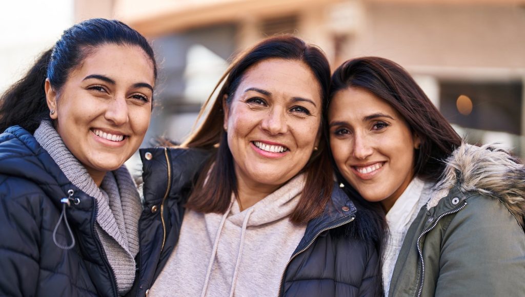 Three woman mother and daughters standing together at street