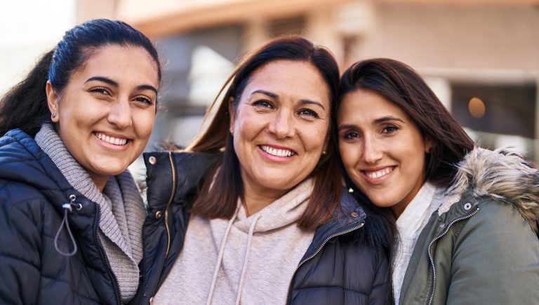 Three woman mother and daughters standing together at street