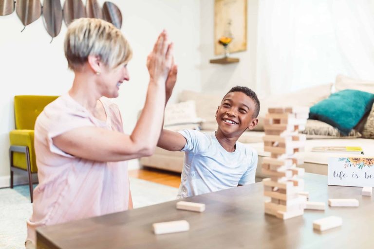 Woman High fiving a boy while playing Jenga