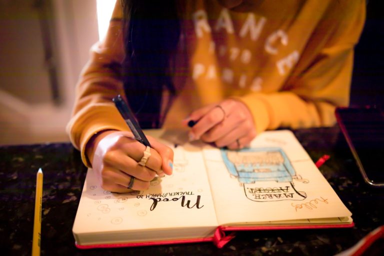 Woman writes in mood tracking journal