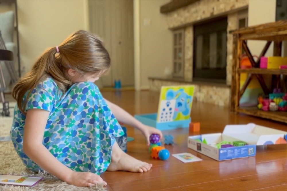 Girl sitting in her house playing on the floor