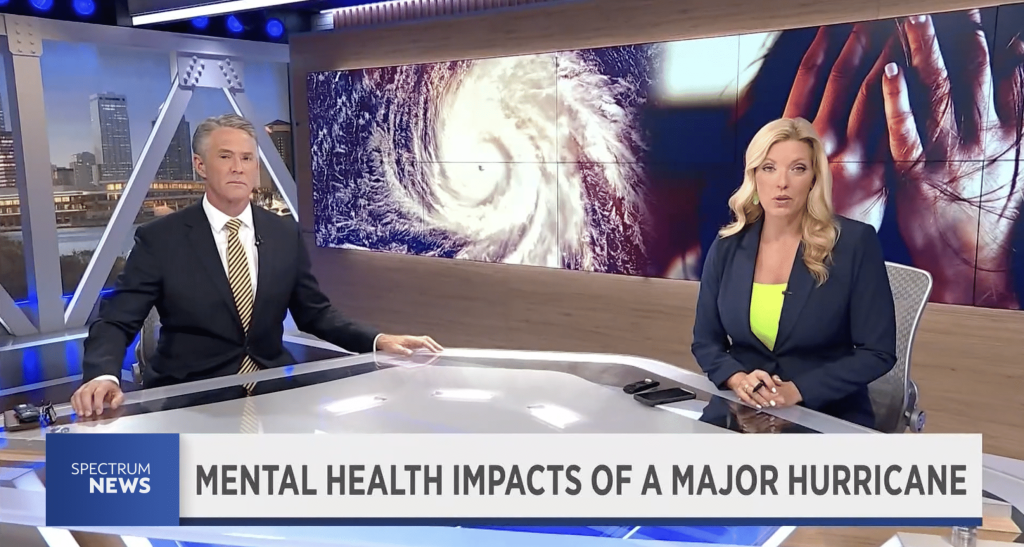 Two news anchors discussing the impacts of recent hurricanes in Fliroda on mental health