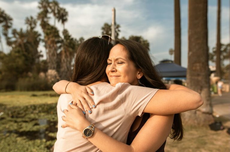 Mom hugging her daughter outside