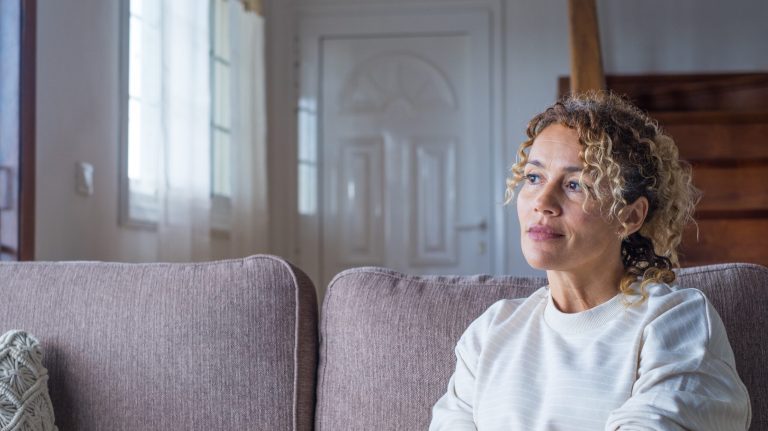 Woman sitting on the couch looking upward while deep in thought
