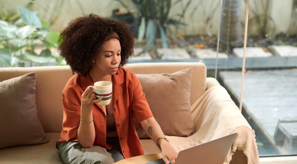 Businesswoman having morning coffee when answering emails