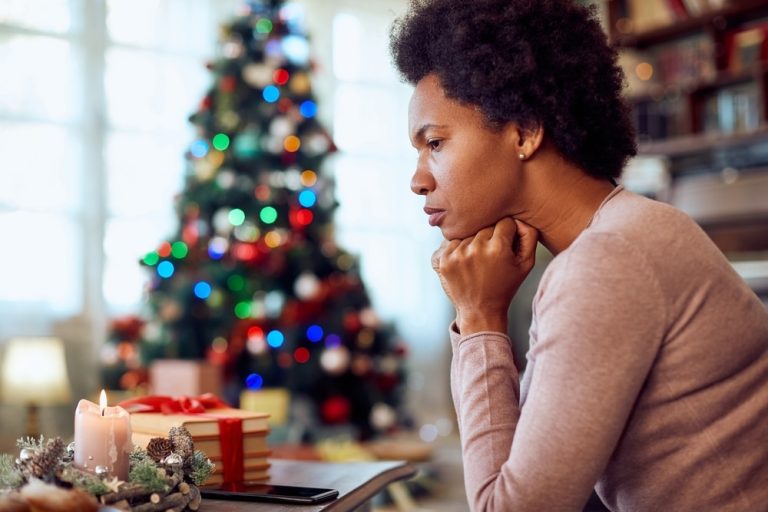 Woman sitting with head on hands experiencing grief on the holidays