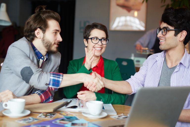 Three adult friends who have learned how to be friends spending time together and shaking hands