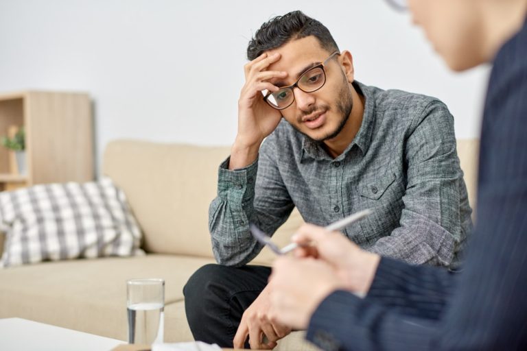 Man in therapy struggling with male mental health stigma