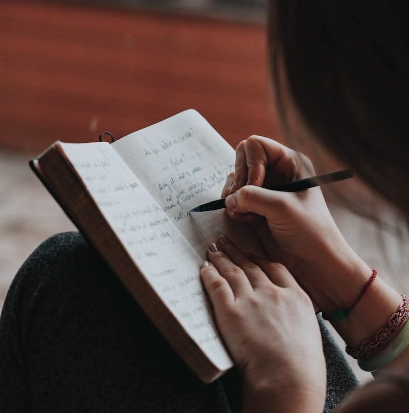 Woman writing down New Year's resolutions