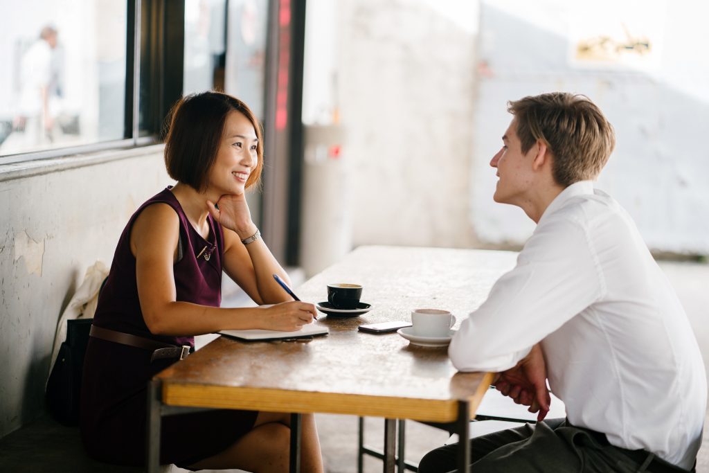 a man and a woman sitting at a table talking