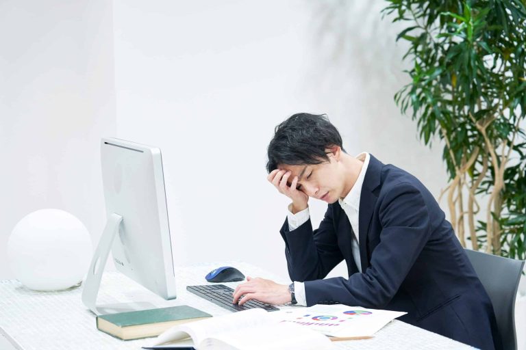 man on his office chair appearing to be in distress