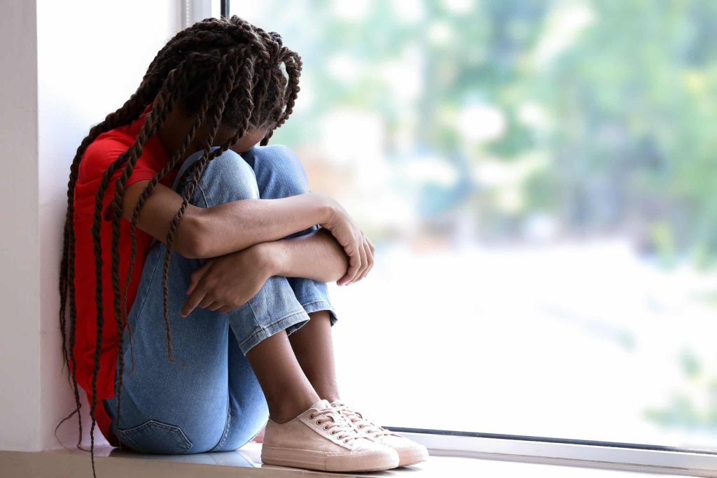 child sitting on the floor with head down