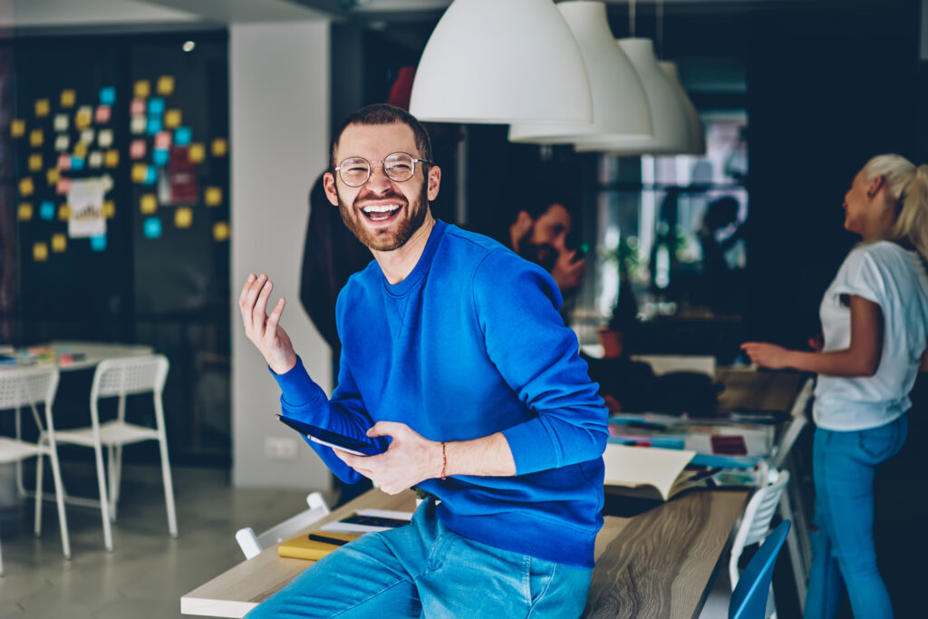 Man in an office building smiling and posing for the camera