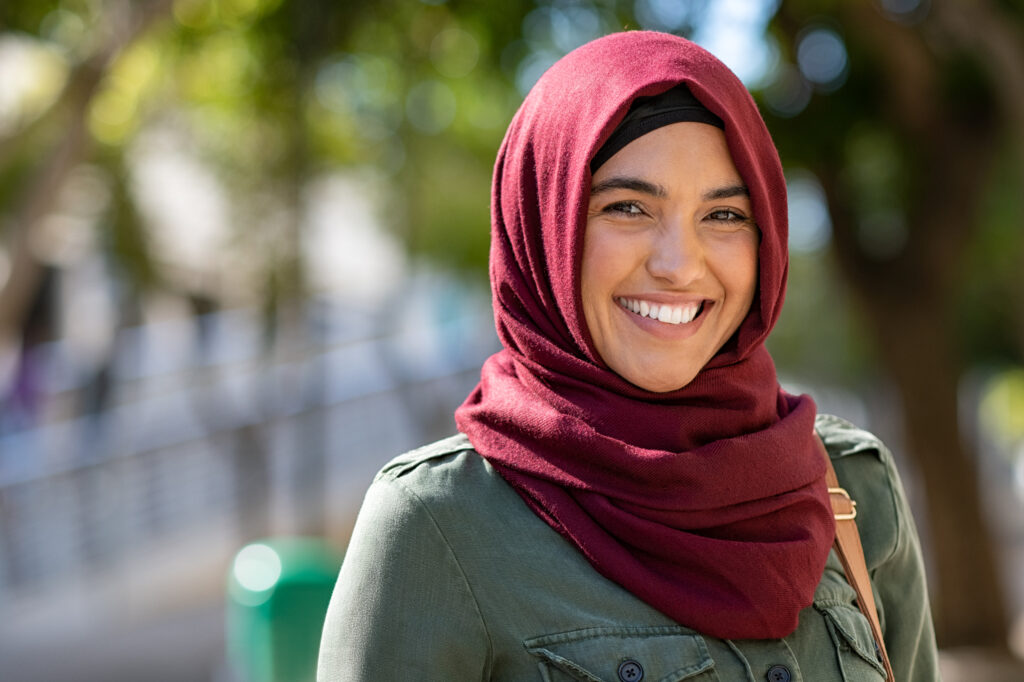 Portrait of young muslim woman wearing hijab in city while looking at camera.