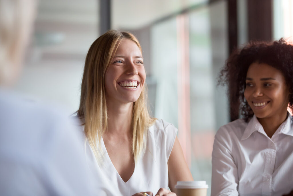 Young woman in a business setting smiling with coworkers
