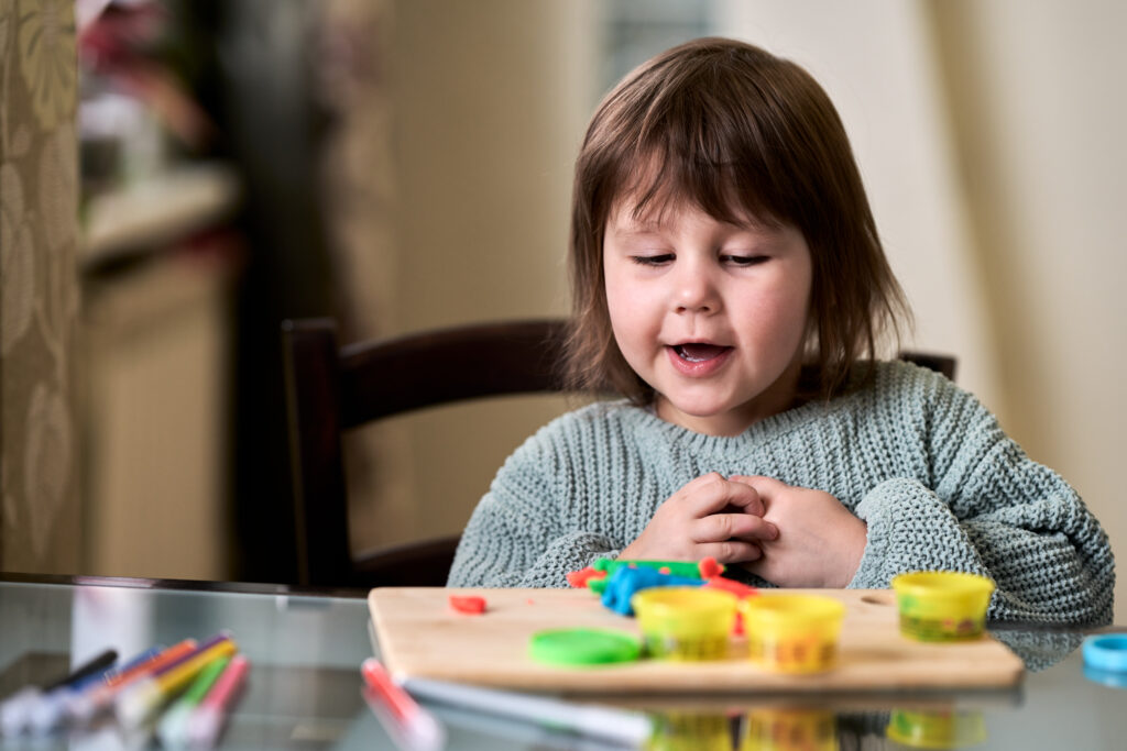 Young child playing with Play-Doh during play therapy