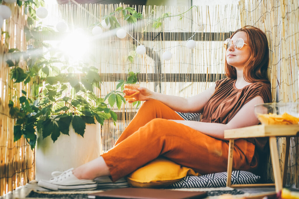 Woman sitting in her backyard next to some plants