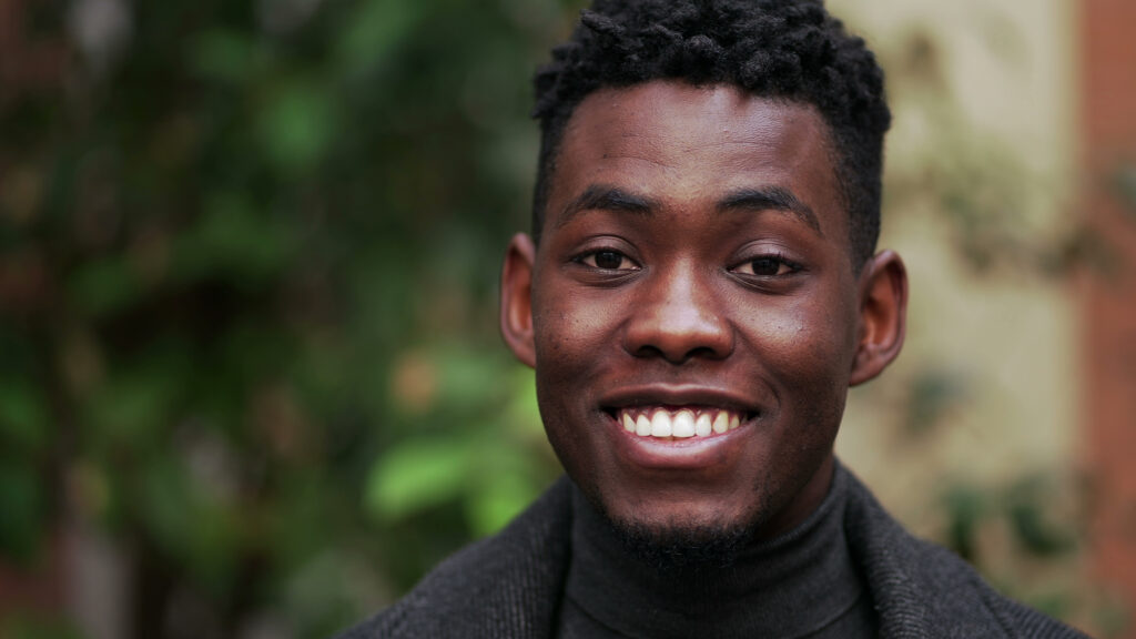 Young adult man standing outside and smiling