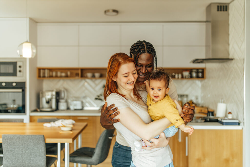 Family with a baby standing in the kitchen