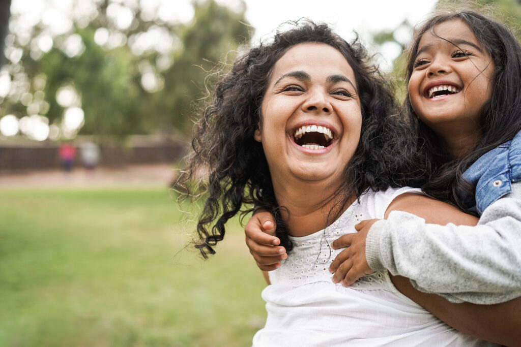 Happy mother and daughter playing outside
