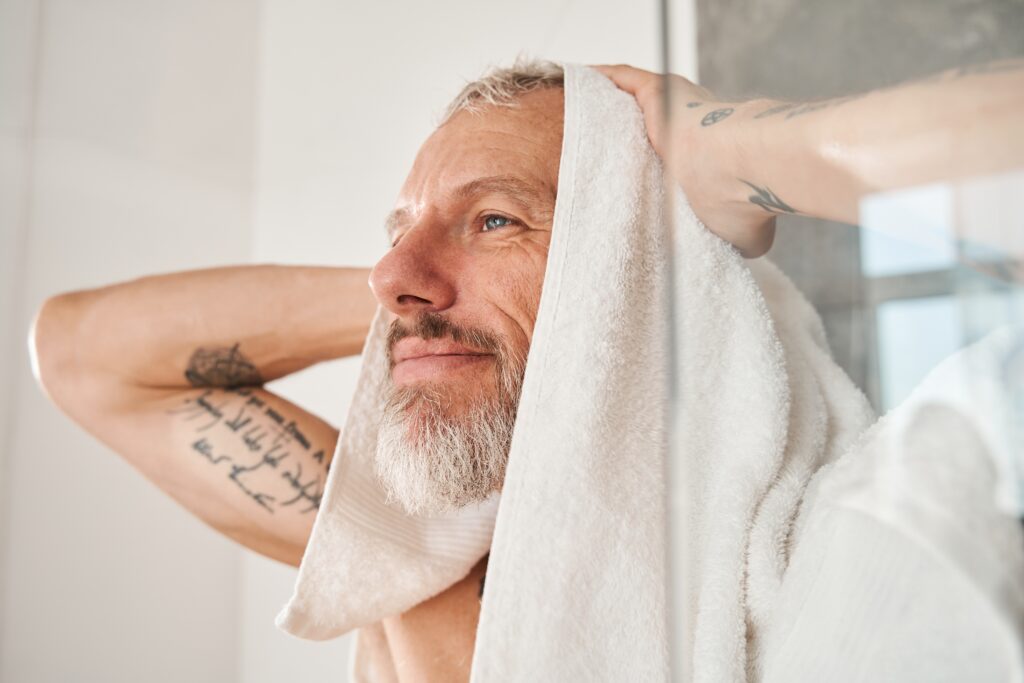 Older man drying his hair with a towel