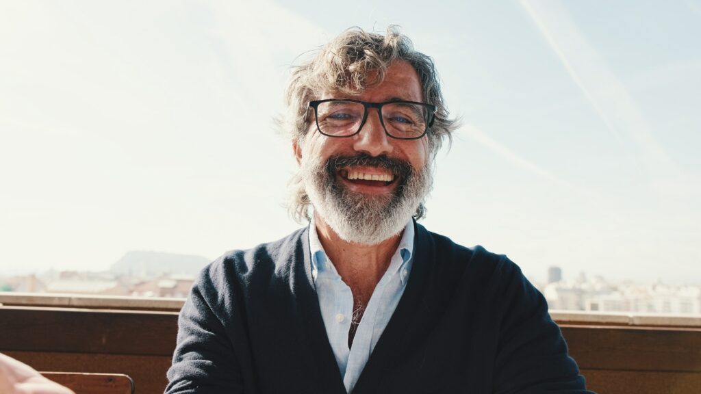 Older man standing outside smiling