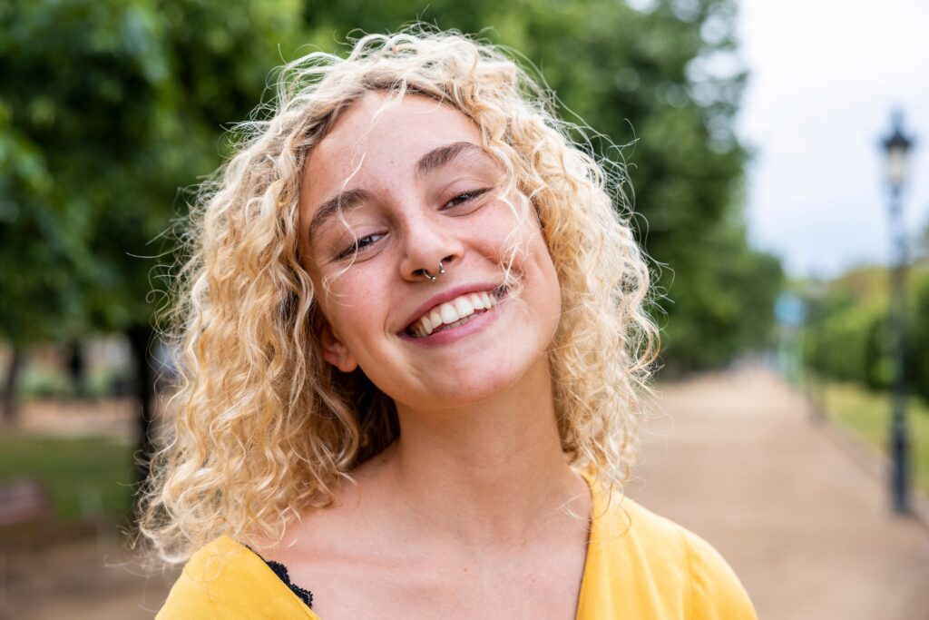 Happy young woman with blond hair in park