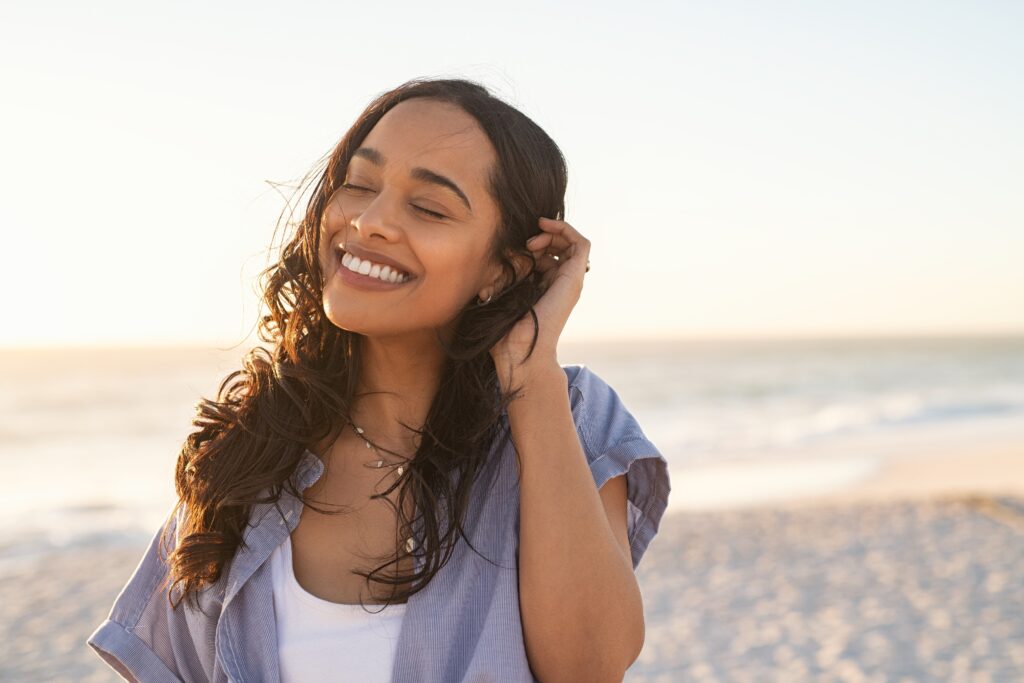 Woman standing on the beach smiling