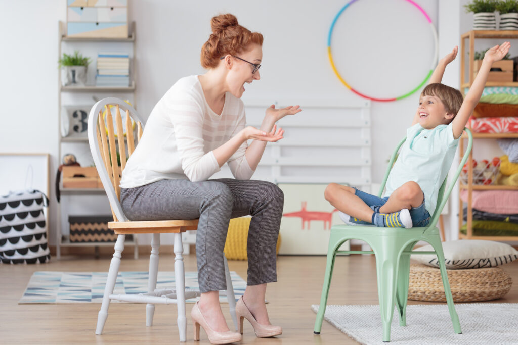 Mom and child sitting in small chairs laughing