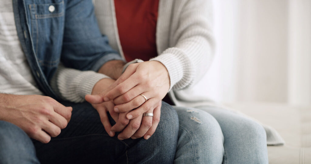 Close up of a married man and woman holding hands